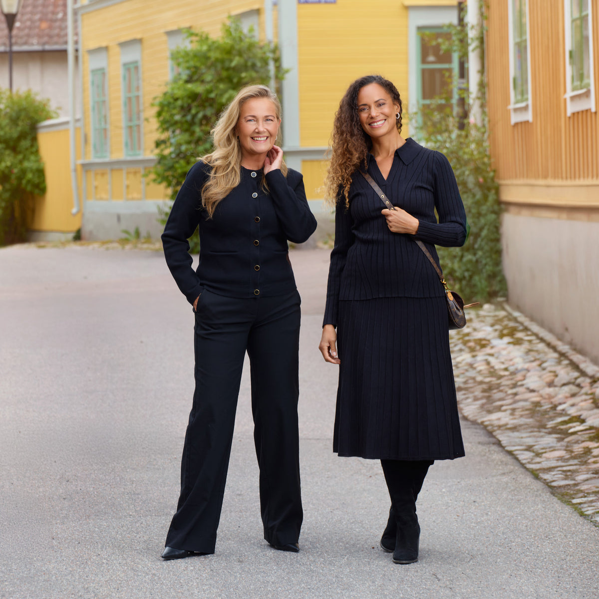 Yvonne Ryding i svart stadigt stickad kofta och bekväma kostymbyxor. Charlene har svart stickad set med smickrande passform
